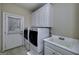 Functional laundry room with washer, dryer, sink, and ample cabinet storage at 415 Oxmoor Lake Dr, Mcdonough, GA 30252