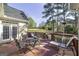 Outdoor patio with furnishings overlooking a green lawn with mature trees in the background at 415 Oxmoor Lake Dr, Mcdonough, GA 30252