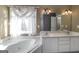 Bright bathroom featuring a soaking tub, dual vanities, and plenty of natural light at 152 Wexford Ct, Stockbridge, GA 30281