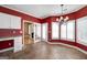 Bright breakfast nook with red walls, a chandelier, and a view of the fireplace through glass doors at 152 Wexford Ct, Stockbridge, GA 30281