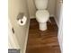 Powder room with dark wood flooring, white toilet and chrome fixtures at 460 Ridgewood Dr, Fayetteville, GA 30215