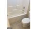 Bathroom featuring a toilet next to a bathtub with tile floor at 460 Ridgewood Dr, Fayetteville, GA 30215