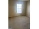 Bright bedroom featuring neutral walls, plush carpeting, and a large window at 460 Ridgewood Dr, Fayetteville, GA 30215