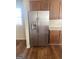Stainless steel refrigerator is nestled between wood cabinets and countertops against dark wood flooring at 460 Ridgewood Dr, Fayetteville, GA 30215
