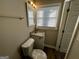 This bathroom has a toilet, a vanity sink, and a mirror with a light fixture above it, plus a window for natural light at 2690 Rollingwood Se Ln, Atlanta, GA 30316