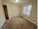 Neutral bedroom featuring plush carpeting, a closet, and a window for natural light at 6380 Phillips Pl, Lithonia, GA 30058
