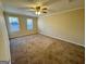 Large bedroom featuring plush carpeting and two windows for natural light at 6380 Phillips Pl, Lithonia, GA 30058