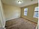This bedroom features neutral walls, plush carpet, and two bright windows offering ample natural light at 6380 Phillips Pl, Lithonia, GA 30058