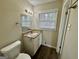 Comfortable bathroom featuring a single sink vanity with granite countertops and a large window providing natural light at 1965 Rollingwood Se Dr, Atlanta, GA 30316