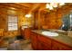 Spacious log cabin bathroom with double sinks and stone tile floor at 1225 Pitts Chapel E, Newborn, GA 30056
