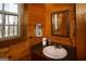 Cozy bathroom with a vessel sink, dark countertop, framed mirror, and natural wood accents at 1225 Pitts Chapel E, Newborn, GA 30056