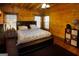 Charming log cabin bedroom with wood paneled walls and ceiling fan at 1225 Pitts Chapel E, Newborn, GA 30056