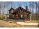 Inviting log cabin with a covered porch, showcasing its rustic charm and natural setting at 1225 Pitts Chapel E, Newborn, GA 30056