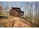 Rustic log cabin exterior showing the side, a small porch, and wooded surroundings at 1225 Pitts Chapel E, Newborn, GA 30056