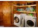 Functional laundry room with a washer, dryer, built-in shelves, and wood door, maximizing space and convenience at 1225 Pitts Chapel E, Newborn, GA 30056