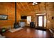 Cozy living room features a wood-burning stove, hardwood floors and natural wood walls, offering warmth and rustic charm at 1225 Pitts Chapel E, Newborn, GA 30056