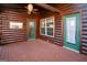 Covered wooden patio of a log cabin, with two green doors and a ceiling fan at 1225 Pitts Chapel E, Newborn, GA 30056