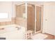 Bathroom with a glass enclosed shower and a white soaking tub at 2920 Stanway Ave, Douglasville, GA 30135