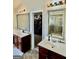 Bathroom featuring double sinks with dark wood cabinets, mirrors and entry to closet at 9444 Lantana Trl, Jonesboro, GA 30238