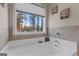 Bright bathroom featuring a soaking tub under a window with a wooded view at 460 Carrie Kathleen Ter, Carrollton, GA 30116