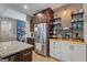 A stainless steel refrigerator compliments the wooden accent wall and granite countertop at 460 Carrie Kathleen Ter, Carrollton, GA 30116