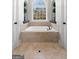 A luxurious bathtub nestled between two doors, beneath an arch window with backyard views at 50 Birch Rd, Covington, GA 30014