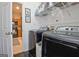 Well-equipped laundry room featuring a storage shelf and modern washer and dryer units at 747 S Fairfield Dr, Peachtree City, GA 30269