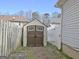 Backyard features a convenient brown and beige storage shed, surrounded by a wooden fence and brick pavers at 747 S Fairfield Dr, Peachtree City, GA 30269