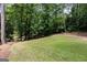 Spacious backyard featuring a large grassy area and lush wooded surroundings at 4421 Paradise Cir, Vinings, GA 30339
