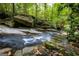 Scenic creek featuring moss-covered rocks and surrounded by trees at 4421 Paradise Cir, Vinings, GA 30339