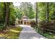 Beautiful home with a circular driveway and stone accents, set against a backdrop of lush greenery at 4421 Paradise Cir, Vinings, GA 30339