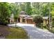 Beautiful home exterior features a stone facade, mature trees, and a paved driveway with great curb appeal at 4421 Paradise Cir, Vinings, GA 30339
