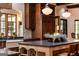 Gourmet kitchen features a stone backsplash, an island with seating and a farmhouse sink illuminated by pendant lighting at 4421 Paradise Cir, Vinings, GA 30339
