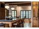 A kitchen island with seating and custom cabinets are illuminated by pendant lights and exposed beams, enhancing the room's ambiance at 4421 Paradise Cir, Vinings, GA 30339