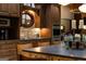 Custom cabinets with a stone backsplash and an oval window compliment the stainless steel appliances in this kitchen at 4421 Paradise Cir, Vinings, GA 30339