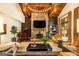 Elegant living room boasts a stone fireplace, wood beams, and a grand piano, perfect for entertaining guests at 4421 Paradise Cir, Vinings, GA 30339