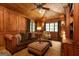 Wood-paneled living room featuring a leather couch and ceiling fan at 4421 Paradise Cir, Vinings, GA 30339