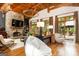 Bright living room features a stone fireplace, wood beams, and access to an outdoor space with a view at 4421 Paradise Cir, Vinings, GA 30339