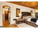 Comfortable main bedroom featuring unique decor, a wooden ceiling, and hardwood floors at 4421 Paradise Cir, Vinings, GA 30339