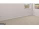 This bedroom has neutral carpet, white walls and trim, and windows for natural light at 624 Kimberwick Dr, Locust Grove, GA 30248