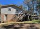Exterior shot of a split-level home with a large wooden deck, staircase and a large backyard at 4935 Liberty Sw Ct, Stone Mountain, GA 30087