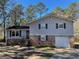 Charming split-level home features a brick facade, attached garage, and mature trees in the front yard at 4935 Liberty Sw Ct, Stone Mountain, GA 30087