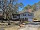 Charming split-level home features a brick facade, attached garage, and mature trees in the front yard at 4935 Liberty Sw Ct, Stone Mountain, GA 30087