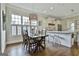 Bright dining area with a modern chandelier, wooden table, and adjacent kitchen with white cabinets at 605 St. Charles Pl, Fayetteville, GA 30215