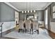 Elegant dining room with wainscoting, gray walls, stylish chairs, and ample natural light at 605 St. Charles Pl, Fayetteville, GA 30215