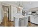 Modern kitchen with an island, marble countertops, white cabinets, and open access to other rooms at 605 St. Charles Pl, Fayetteville, GA 30215