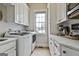 Well-lit laundry room featuring front loading washer and dryer, counter space, and ample cabinet storage at 605 St. Charles Pl, Fayetteville, GA 30215