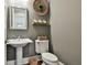 Elegant powder room with a pedestal sink, framed mirror, and tasteful decor at 605 St. Charles Pl, Fayetteville, GA 30215