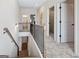Upstairs hallway features a railing, carpeted floors, and views of the stairway at 10459 Trellis Lane (Lot 27), Hampton, GA 30228