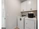 Convenient laundry room with modern washer and dryer and upper cabinets for storage at 10459 Trellis Lane (Lot 27), Hampton, GA 30228